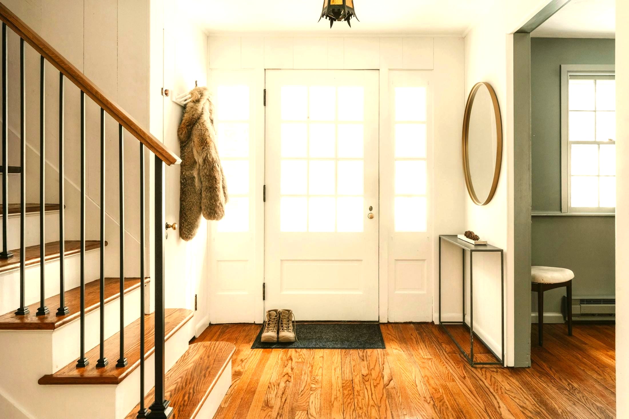 A bright entrance hall with a glass door open to daylight