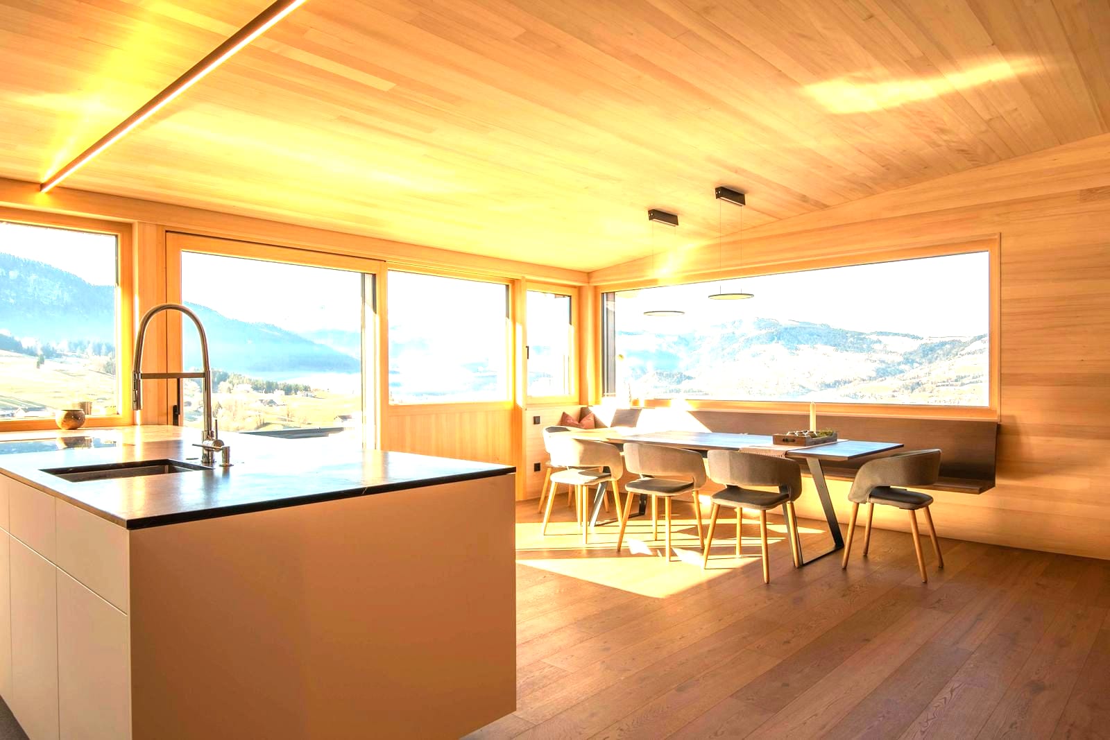 A room with chairs and a long table under tall windows