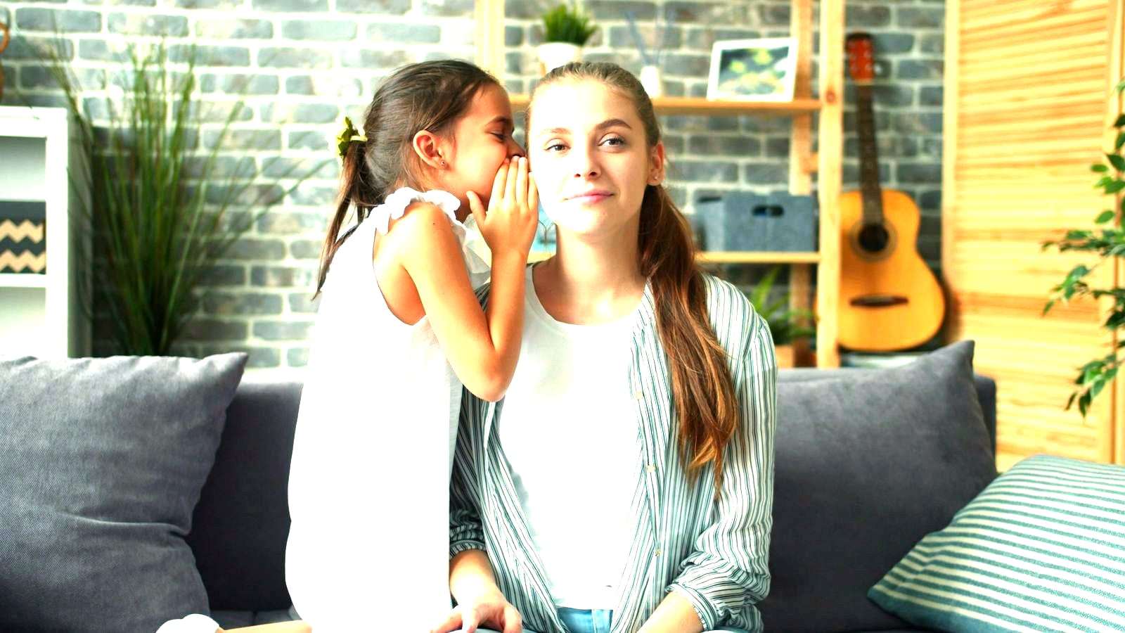 A child leaning in to tell an adult something